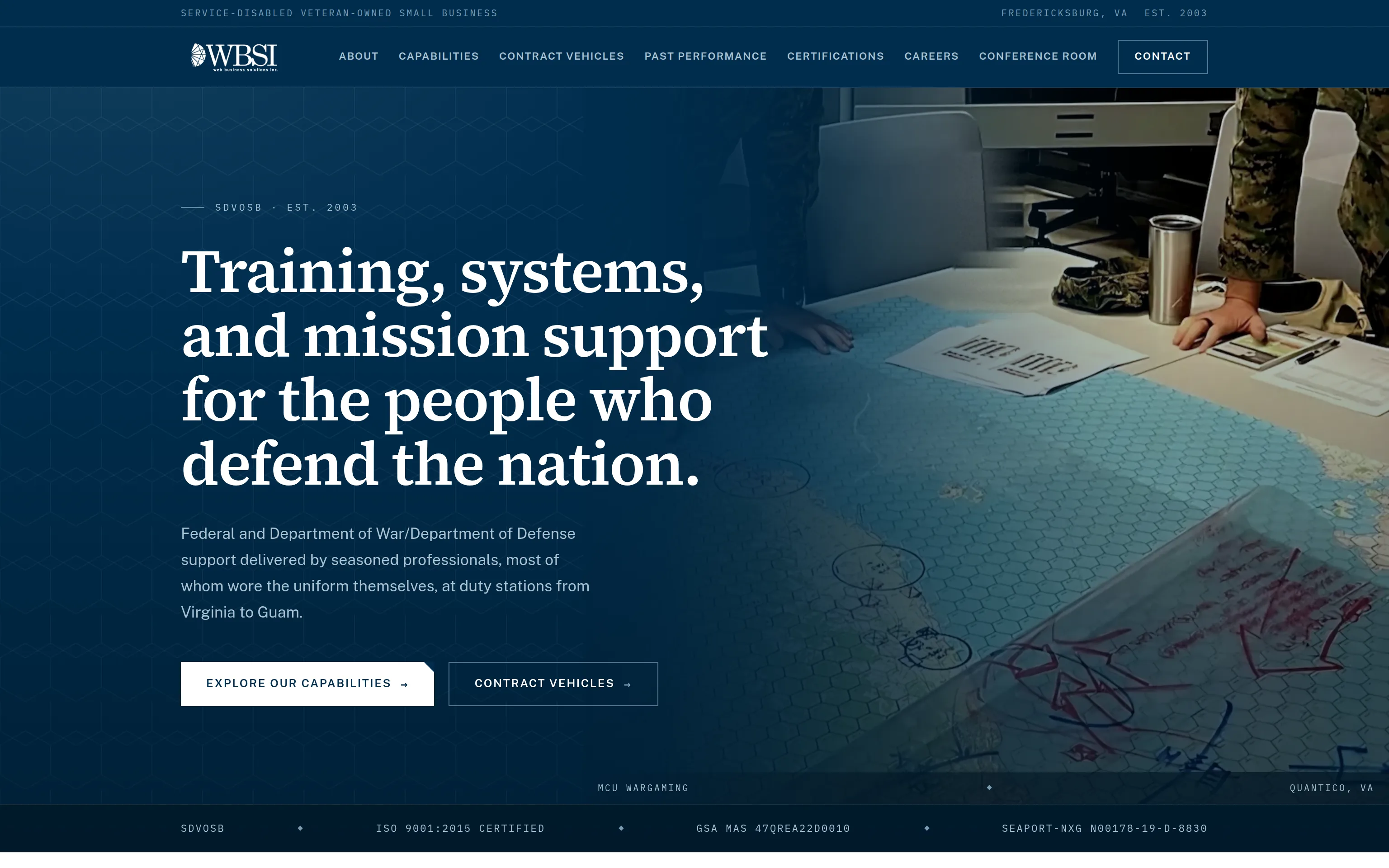The WBSI homepage: a deep navy hero over a photograph of a wargaming map table, with the serif headline 'Training, systems, and mission support for the people who defend the nation', two buttons, and a credential strip listing SDVOSB, ISO 9001:2015, and two contract numbers.